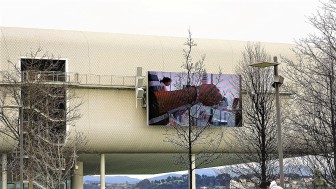 Op de foto zien we het grote scherm aan de buitenkant van het Centro Botín. Een scherm waar alle exposities extra aandacht krijgen.