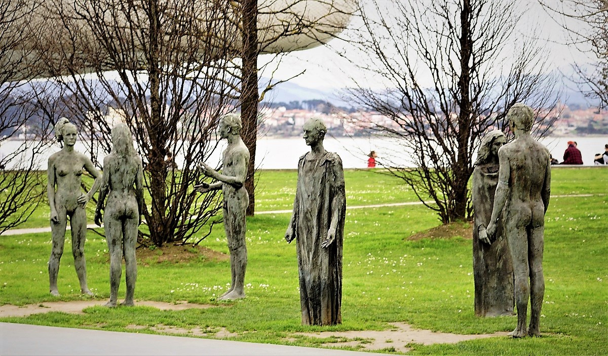 Een foto van het monument van de reconstructie van Santander dat uitgebeeld wordt door bronzen beelden van geklede op oude Grieken gelijkende figuren en naakte moderne figuren.